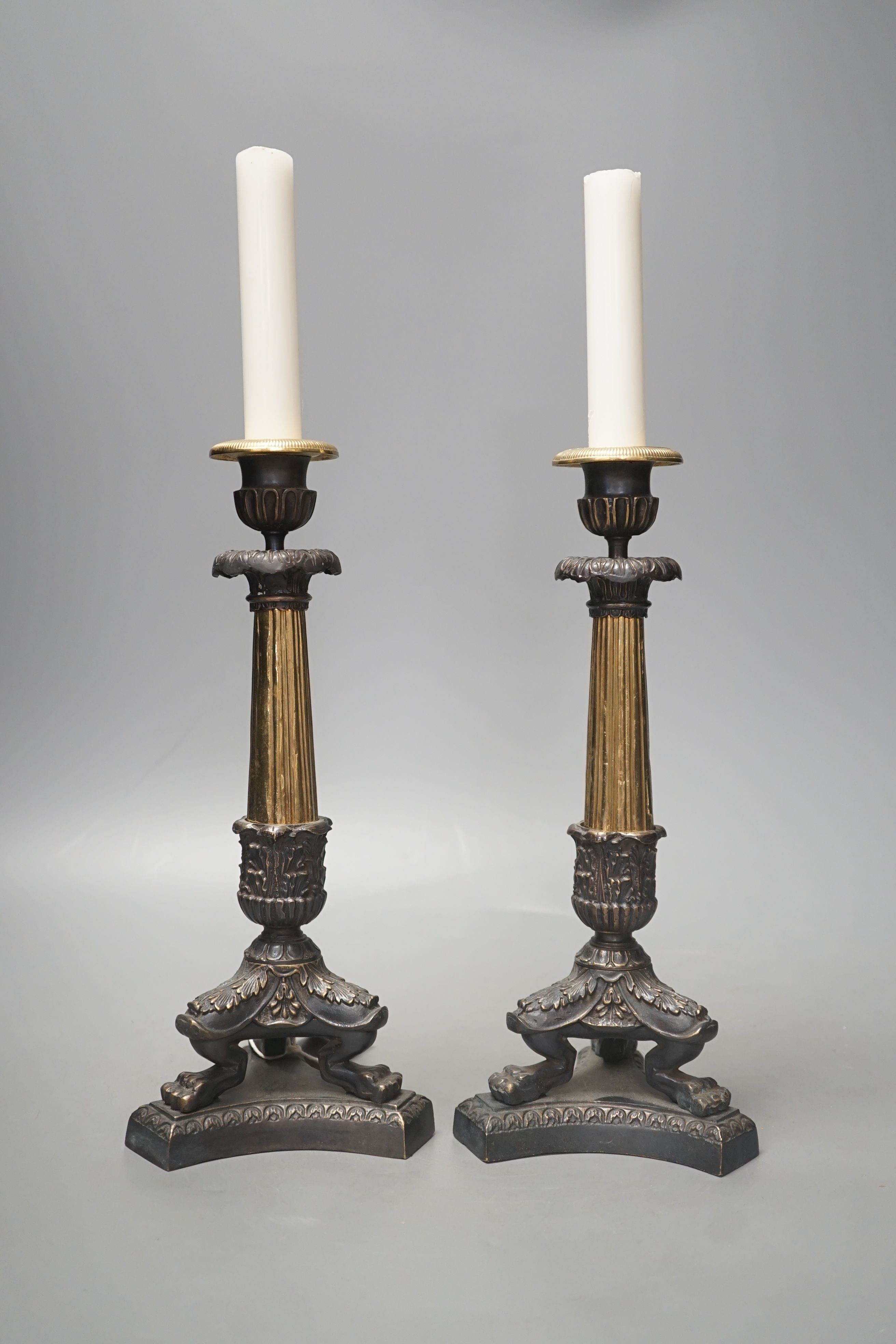 A pair of neo-classical style brass candlesticks, 28.5 cms high.